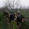 Ukrainische Marinesoldaten gehen durch Gelände an der Frontlinie in Cherson.