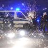 Polizeibeamte stehen am Silvesterabend hinter explodierendem Feuerwerk.