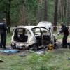 Die Polizei sichert in einem abgesperrten Waldstück bei Börnicke (Havelland) den Fundort. Zwei tote Kinder sind in einem ausgebrannten Auto gefunden worden.