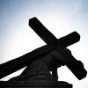 Unter blauem Himmel und gegen die Sonne zeichnet sich eine Jesusstatue unter dem Kreuz ab. Die katholische Kirche steckt in der Krise.