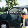 Ein Feuerwehrmann steht neben einem Kleinbus. Ein mutmaßlicher Räuber hat sich nach einem Banküberfall in Bayern in dem Bus in die Luft gesprengt.