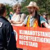 Ein Aktivist (r.) der Klimaschutzorganisation «Letzte Generation» protestiert vor dem Nürnberger Hauptbahnhof.