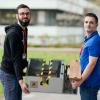 Marvin Schmauder (r) und Jacob Herdtweck halten im Karlsruher Institut für Technologie (KIT) beim Landeswettbewerb «Jugend forscht» ein Besenreinigungsgerät in den Händen.