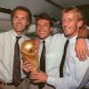 Franz Beckenbauer, Lothar Matthäus und Andreas Brehme (v.l.) posieren stolz mit dem WM-Pokal. Bis 1994 spielte Brehme in der Nationalmannschaft.