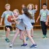 Mit Eifer bei der Sache: Schüler spielen gemeinsam und gegeneinander in der Grundschulliga Basketball. Langfristig von diesem Projekt profitieren wollen Augsburger Sportvereine.  	