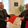 DRW-Direktor Walter Merkt erhält von Bischof Bertram das Ernennungsdekret überreicht. Walter Merkt wechselt in die Aufsicht des Caritasverbandes auf diözesaner Ebene.  	
