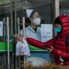 Eine Frau holt in einer Apotheke in Peking Covid-19-Antigen-Kits ab.