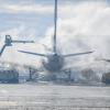 Ein Flugzeug wird am Münchner Flughafen von Eis befreit.
