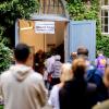 Wählerinnen und Wähler warten im Stadtteil Prenzlauer Berg in einer langen Schlange vor einem Wahllokal, das in einer Grundschule untergebracht ist.