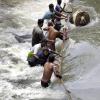 In einem Vorort von Colombo versuchen Menschen sich durch die reißenden Wassermassen zu kämpfen.
