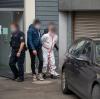Polizisten bringen einen der Tatverdächtigen im weißen Overall nach dem Haftprüfungstermin am Landgericht Kaiserslautern aus dem Justizgebäude.