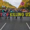 Umwelt-Aktivisten halten ein Plakat mit der Aufschrift "Stop Killing Us".