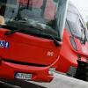 Ein Regionalbus und ein Regionalzug stehen am Bahnhof in Murnau nebeneinander.