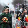 Königin Mathilde von Belgien wird von wartenden Zuschauern mit belgischen Fähnchen am Brandenburger Tor begrüßt.