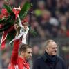 Bayern-Kapitän Philipp Lahm (l) erhält von Vorstandschef Karl-Heinz Rummenigge einen Blumenstrauß für sein 500. Pflichtspiel für den FC Bayern.