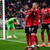 Leverkusens Torschütze Amine Adli (l-r) jubelt nach seinem Tor zum 0:2 mit Mitchel Bakker und Edmond Tapsoba.