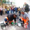 Zwei Mitarbeiter des Bauhofs verlegen Stolpersteine in der Ulmer Hirschstraße, im Hintergrund Yvonne Schefler und Mark Tritsch von der Initiative Stolpersteine für Ulm.