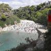 Menschen nehmen einen Sonnenbad am Strand Cala Pi.