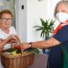 Regina Opolka (links) nimmt ein Lebensmittelpaket von Gabriele Rölz an. Sie und andere Freiwillige helfen mit dem monatlichen Einkauf Senioren, die in einer finanziell schwierigen Situation sind. 