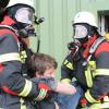 Auch mit schweren Atemschutzgeräten müssen die jungen Feuerwehrleute im Ernstfall umgehen können. Hier retten sie Menschen aus einer Lagerhalle, in der es zu einer fiktiven Explosion gekommen ist.  	