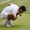Novak Djokovic probiert vor lauter Freude den heiligen Rasen von Wimbledon.