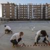 Lehrer machen mit Klebeband Markierungen auf einem Schulhof in Madrid, um den Sicherheitsabstand zwischen den Schülern zu gewährleisten.