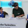 Der frühere Aichacher Polizeichef Rudolf Rothhammer probiert am AN-Stand die virtuelle Achterbahnfahrt mit VR-Brille aus. 