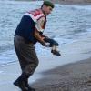 Ein Polizist trägt die Leiche des Dreijährigenweg. Er war am Strand von Bodrum angespült worden. Sein Vater hatte einem Schleuser 4000 Euro gezahlt, damit er die Familie auf die griechische Insel Kos bringt.