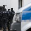 Polizisten und ein Polizeiwagen stehen vor einem Wohnhaus im Ortsteil Vieselbach. Bundesinnenminister Seehofer (CSU) hat die rechtsextreme Gruppe „Combat 18“ verboten. 