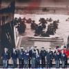 Es brandet Beifall auf, als diese Veteranen bei der Gedenkfeier in Portsmouth die Bühne betreten. Und im Hintergrund ist zu sehen, wofür diese Männer bei der Veranstaltung geehrt werden.