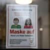 Schilder am Eingang eines Behördengebäudes des Landratsamts Günzburg informieren während der Corona Pandemie über die Tragepflicht einer Mund-Nasenschutz-Maske. Gesundheit Sicherheit Schutz Vorsorge