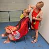 Nataliy schneidet ihrer Mitbewohnerin Juliana in einem Durchgang die Haare.               