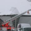 Die Feuerwehr hilft mit ihrer Drehleiter beim Räumen des Eishallen-Dachs. 