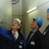 Kraftwerksleiter Michael Trobitz (links) erklärt Aaron Szabo (Mitte) und Jerome O. Bettle von der United States Nuclear Regulatory Commission die Technik der gefilterten Druckentlastung. 
