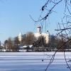 Das Schloss von Höchstädt im Winterkleid. Im Vordergrund der zugefrorene Baggersee. 
