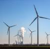 Der Schornstein und die Kühltürme eines Braunkohlekraftwerks dampfen hinter einem Windpark. Der vorzeitige Kohleausstieg wird in Deutschland kontrovers diskutiert.