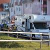 Feuerwehrleute und Polizisten stehen am 4.11.2011 in Eisenach vor dem ausgebrannten Wohnwagen von Böhnhardt und Mundlos.