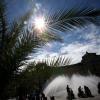 Die Sonne lockt die Menschen an den Brunnen am Karlsplatz (Stachus) in München (Bayern). Nächste Woche soll es endlich wieder wärmer werden.