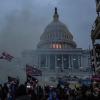 Das Kapitol ist zum Schauplatz eines historischen Angriffs auf die Demokratie geworden. Die Luft ist grau von Rauch und Tränengas, als Polizisten versuchen, die Randalierer aufzuhalten.