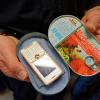 Ein Mitarbeiter eines sächsischen Gefängnis präsentiert ein in einer Fischdose verstecktes Mobiltelefon eins Gefangenen. 