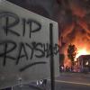 «RIP Rayshard» steht auf einem Schild, während im Hintergrund ein Wendy's-Restaurant brennt.