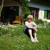 Helma Wisnewski sitzt zwischen blühenden Margeriten in ihrem Garten.