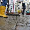 Helfer reinigen in der vom Elbehochwasser betroffenen Stadt Meißen (Sachsen) das Straßenpflaster.