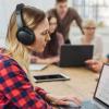 Während sich die Kollegen unterhalten, ist es oft nicht so leicht, sich auf die eigene Arbeit zu konzentrieren. Viele Büro-Angestellte greifen dann auf Kopfhörer zurück.