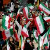 Zuschauerinnen schwenken im Stadion in Teheran Iran-Flaggen.