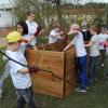 Cornelia Ast zeigte den Kindern, wie man ein Hochbeet aufbaut und mit verschiedenen Schichten aus Zweigen sowie Erde befüllt. 