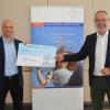 Dachser-Speditionsleiter Christian Schnabel (links) übergibt Gersthofens Bürgermeister Michael Wörle einen Scheck über 5000 Euro für die Stiftung Hilfe in Not Gersthofen.
