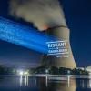 Greenpeace-Aktivisten projizieren "Riskant & überflüssig" an den Kühlturm am Kernkraftwerk Isar 2.