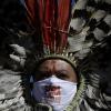 "Bolsonaro raus": Die Mundschutzmaske eines indigenen Anführers bei einer Protestaktion gegen Brasiliens Präsidenten hat eine klare Aussage.
