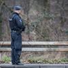 Ein Polizist steht am 07.03.2017 in Herne Nordrhein-Westfalen vor einem Waldstück.